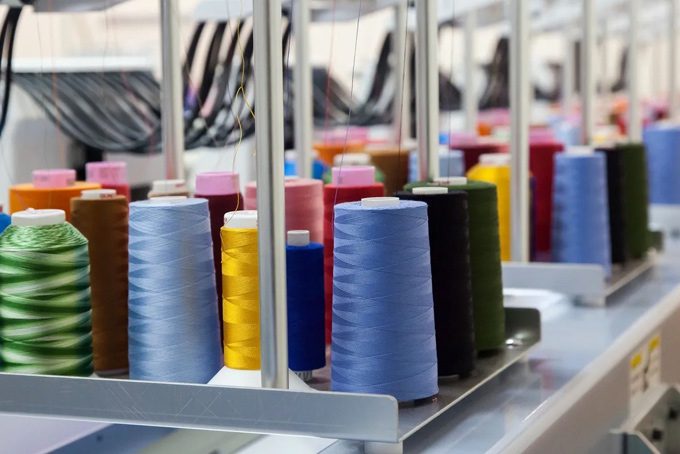 A row of spools of thread on a table.