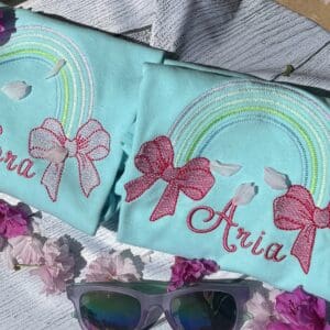 A pair of sunglasses and two shirts with bows on them.